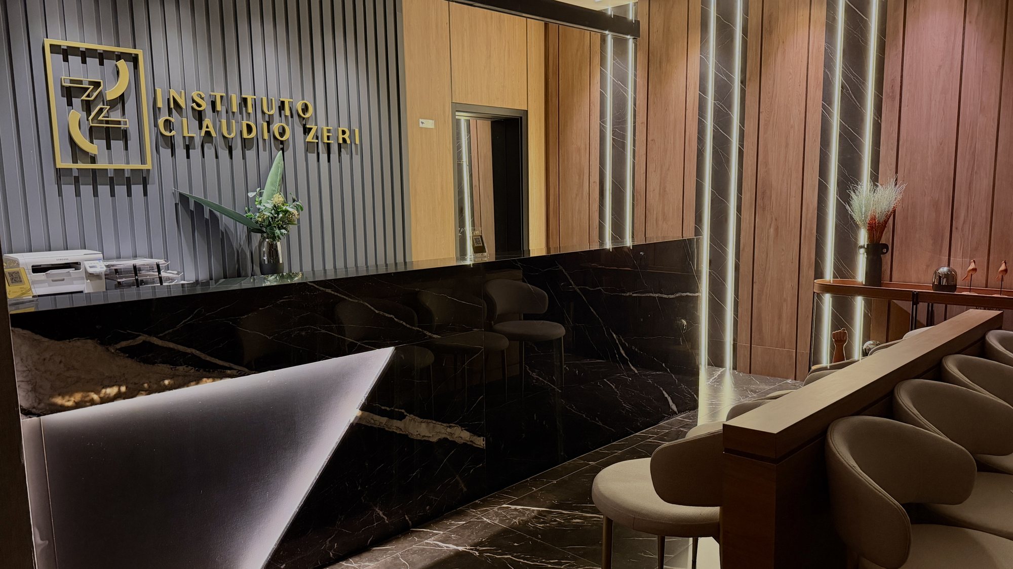Recepção do Instituto Claudio Zeri, com bancada de mármore escuro e logotipo em dourado.
